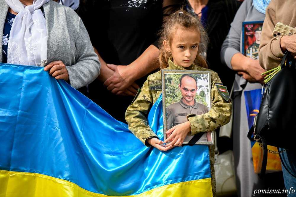 Українців важко переконати, що треба любити своїх ворогів. Дівчинка тримає портрет загиблого батька. 